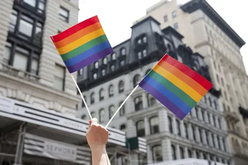 A person holds up LGTBQ+ pride flags during the Pride Parade in New York, June 24, 2018. (AP Photo/Steve Luciano, File)