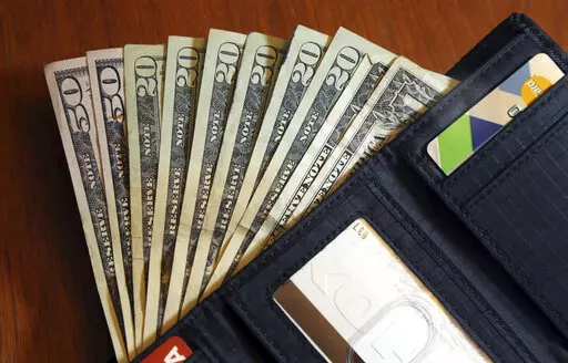 In this June 15, 2018, file photo, cash is fanned out from a wallet in North Andover, Mass. Employee benefits are one of the most attractive things about a prospective job and can determine whether you take an opportunity or leave it. When you do decide to take the job, do you maximize the benefits?   (AP Photo/Elise Amendola, File)
