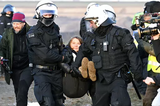 Police officers carry Swedish climate activist Greta Thunberg away from the edge of the Garzweiler II opencast lignite mine during a protest action by climate activists after the clearance of Luetzerath, Germany, Tuesday, Jan. 17, 2023. After the eviction of Luetzerath ended on Sunday, coal opponents continued their protests on Tuesday at several locations in North Rhine-Westphalia. (Federico Gambarini/dpa via AP)
