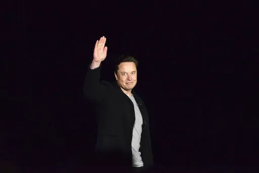 Elon Musk waves while providing an update on SpaceX's Starship, Thursday, Feb. 10, 2022, near Brownsville, Texas. In April 2022, a group of Tesla shareholders suing Musk over some 2018 tweets about taking the company private is asking a federal judge to order him to stop commenting on the case. (Miguel Roberts/The Brownsville Herald via AP, File)