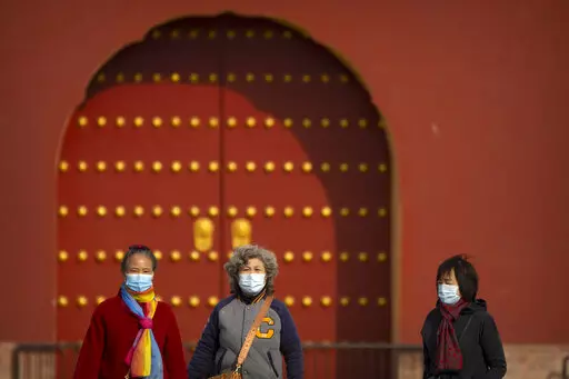 People wearing face masks walk at the Temple of Heaven in Beijing, Saturday, Nov. 12, 2022. Everyone in a district of 1.8 million people in China's southern metropolis of Guangzhou was ordered to stay home Saturday to undergo virus testing and a major city in the southwest closed schools as another rise in infections was reported. (AP Photo/Mark Schiefelbein)