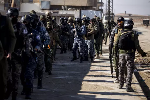 US backed Syrian Democratic Forces soldiers search for Islamic State militants in Hassakeh, Syria, Friday, Jan. 28, 2022. Friday's search came as U.S.-backed fighters set a deadline for dozens of armed extremists who remained holed up in a small part of the jail to surrender or face an all-out attack. (AP Photo/Baderkhan Ahmad)