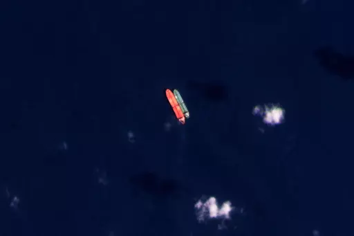 In this satellite photo provided by Planet Labs PBC, vessels identified as the Virgo, left, and the Suez Rajan, by the advocacy group United Against Nuclear Iran, are seen in the South China Sea on Feb. 13, 2022. A Greek shipper has pleaded guilty to a charge over it smuggling sanctioned Iranian crude oil and agreed to pay a $2.4 million fine, U.S. federal court papers seen Thursday, Sept. 7, 2023 by The Associated Press show. (Planet Labs PBC via AP, File)