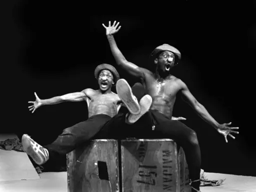FILE — Performers Percy Mtwa, left, and Mbongeni Ngema in a scene from "Woza Albert" at the Market Theatre in Johannesburg, South Africa, in 1981. Ngema, enowned South African playwright, producer and composer has died in a fatal car crash at the age of 68, his family confirmed on Wednesday, Dec. 27, 2023. (AP Photo/Ruphin Coudyzer/File)