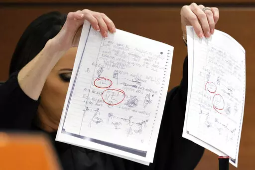 EDS NOTE: OBSCENITY - Judge Elizabeth Scherer holds up documents as she considers arguments from the defense that the jury should be prevented from seeing the swastikas on the pages (circled in red) during the penalty phase of the trial of Marjory Stoneman Douglas High School shooter Nikolas Cruz at the Broward County Courthouse in Fort Lauderdale, Fla., on Thursday, Sept. 1, 2022. Cruz previously pleaded guilty to all 17 counts of premeditated murder and 17 counts of attempted murder in the 201