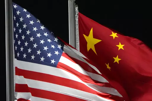 The American and Chinese flags wave at Genting Snow Park ahead of the 2022 Winter Olympics, Feb. 2, 2022, in Zhangjiakou, China. The Biden administration is close to finalizing new regulations that would tighten rules on certain overseas U.S. investment, a move aimed at limiting Beijing’s ability to acquire advanced technologies. That's according to a U.S. official familiar with deliberations who was not authorized to comment. (AP Photo/Kiichiro Sato, File)