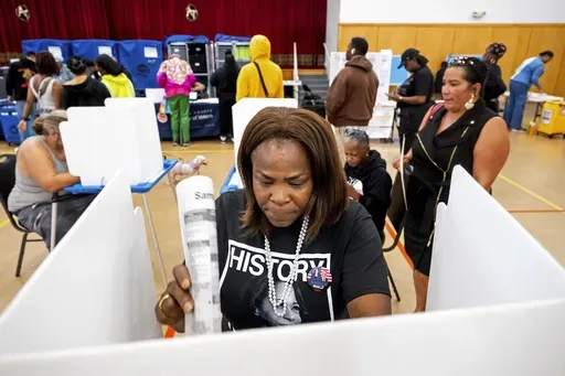 Sheron Campbell wears a Kamala Harris shirt while voting on Election Day in Oakland, Calif., Tuesday, Nov. 5, 2024. (AP Photo/Noah Berger)