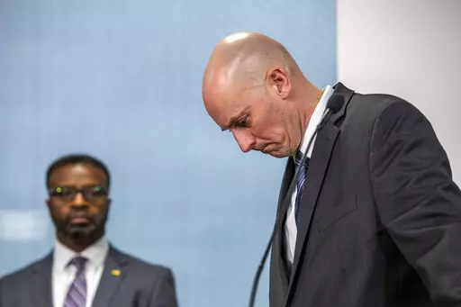 Grand Rapids Police Chief Eric Winstrom, right, and Grand Rapids City Manager Mark Washington react as a TV display shows video evidence of a Grand Rapids police officer struggling with and shooting Patrick Lyoya at Grand Rapids City Hall on Wednesday, April 13, 2022. Lyoya, 26, was shot and killed about 8:10 a.m., on April 4, after what police said was a traffic stop. (Cory Morse/The Grand Rapids Press via AP)