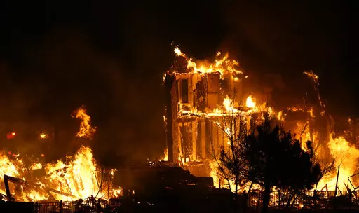 Homes burn as a wildfire rips through a development near Rock Creek Village, Thursday, Dec. 30, 2021, near Broomfield, Colo. An estimated 580 homes, a hotel and a shopping center have burned and tens of thousands of people were evacuated in wind-fueled wildfires outside Denver, officials said Thursday evening.  (AP Photo/David Zalubowski)