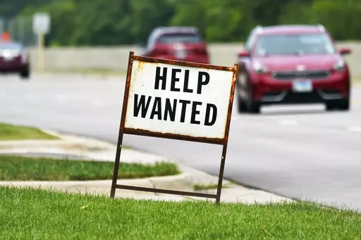 A help wanted sign is displayed at a gas station in Mount Prospect, Ill., Tuesday, July 27, 2021.  Fewer Americans applied for unemployment benefits last week as layoffs remain at historically low levels.  Jobless claims fell by 5,000 to 166,000 for the week ending April 2, 2022 the Labor Department reported Thursday.  (AP Photo/Nam Y. Huh)