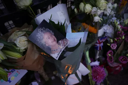 Messages, flowers and candles are seen at the gates of Buckingham Palace in London, Friday, Sept. 9, 2022. (AP Photo/Kirsty Wigglesworth)