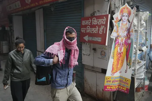 A office goer walks wearing a face mask amidst a thick layer of smog as air pollution shoots up in New Delhi, India, Monday, Nov. 18, 2024. (AP Photo/Manish Swarup)