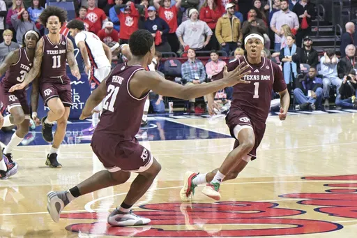 Texas A&M guard Zhuric Phelps (1) and Texas A&M forward Pharrel Payne (21) celebrate the win over Mississippi during the second half of an NCAA college basketball game in Oxford, Miss., Wednesday, Jan. 22, 2025. (AP Photo/Bruce Newman)