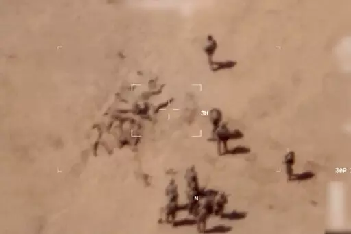 This image taken from a video shows soldiers burying bodies near an army base in northern Mali. The French military says it has videos of Russian mercenaries burying bodies near an army base in northern Mali which it says is part of a smear campaign against the French who handed control of the base to Malian forces earlier this week. Aerial surveillance taken by the French military early Thursday and provided to The Associated Press show what appear to be 10 Caucasian soldiers covering approxima