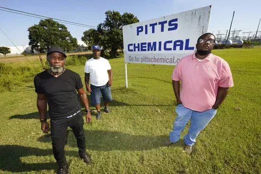 Richard Strong, left, his brother Gregory Strong, center, and Stacy Griffin pose for a photo on Sept. 9, 2021, in Indianola, Miss. They are among Black farmworkers in Mississippi who said in a lawsuit that their former employer, Pitts Farm Partnership, brought white laborers from South Africa to do the same jobs they were doing, and that the farm violated U.S. law by paying the white immigrants significantly more for the same type of work. The lawsuit and a similar one filed by other Black worke