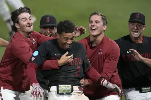 Stanford's Drew Bowser (2) celebrates with teammates after hitting a single to score the winning run against Texas in the ninth inning of an NCAA college baseball tournament super regional game in Stanford, Calif., Monday, June 12, 2023. Stanford won 7-6. (AP Photo/Tony Avelar)