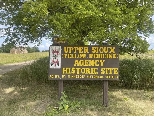 A large wooden sign that says "Upper Sioux (Yellow Medicine) Agency Historic Site" stands at the Upper Sioux Agency State Park near Granite Falls, Minn., on July 28, 2023. The golden prairies and winding rivers of the state park also hold the secret burial sites for Dakota people who died as the U.S. failed to fulfill treaties with Native Americans over a century ago — and now their descendants are getting that land back. (AP Photo/Trisha Ahmed)