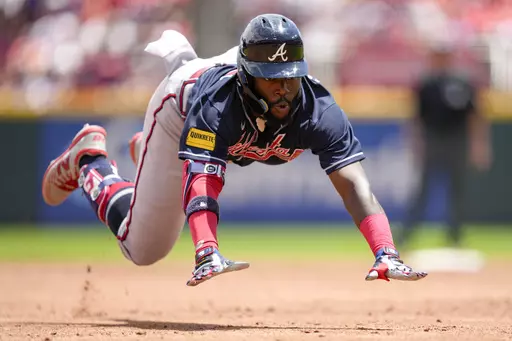 Atlanta Braves' Michael Harris II dives into third base on a triple against the Cincinnati Reds during the third inning of a baseball game Sunday, June 25, 2023, in Cincinnati. (AP Photo/Jeff Dean)
