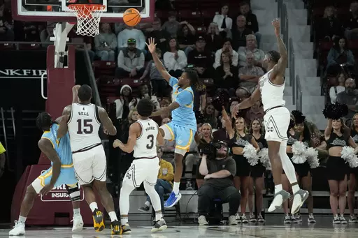 Southern University guard Brandon Davis, second from right, makes a banked shot to score in the final seconds against Mississippi State during the second half of an NCAA college basketball game, Sunday, Dec. 3, 2023, in Starkville, Miss. (AP Photo/Rogelio V. Solis)