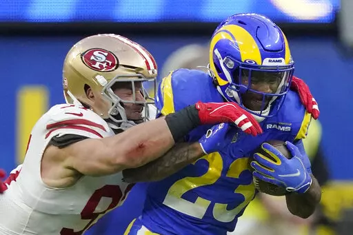 San Francisco 49ers' Nick Bosa, left, stops Los Angeles Rams' Cam Akers during the first half of the NFC Championship NFL football game Sunday, Jan. 30, 2022, in Inglewood, Calif. (AP Photo/Mark J. Terrill)