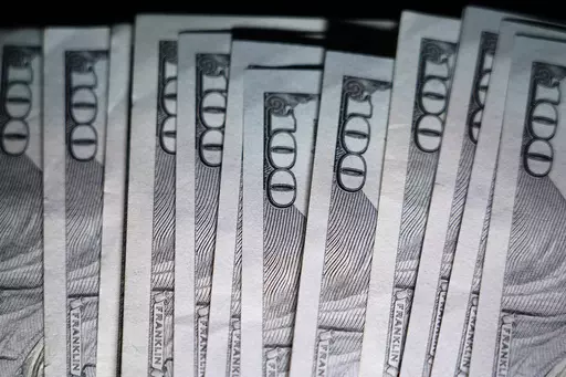 U.S. $100 bills are seen, Thursday, July 14, 2022, in Marple Township, Pa. As we get older it’s important to shift from aggressive, stock-based investments to less risky investments to protect our hard-earned money from market drops. Here’s how to allocate your money to align your investment strategies with your middle years. (AP Photo/Matt Slocum)