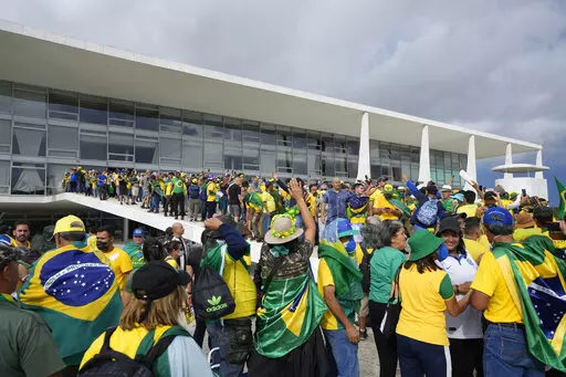 Protesters, supporters of Brazil's former President Jair Bolsonaro, storm the Planalto Palace in Brasilia, Brazil, Sunday, Jan. 8, 2023. Planalto is the official workplace of the president of Brazil. (AP Photo/Eraldo Peres)
