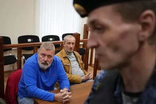 Nobel Peace Prize awarded journalist Dmitry Muratov, editor-in-chief of the influential Russian newspaper Novaya Gazeta, left, and Sergei Sokolov, his deputy, sit in a courtroom prior to a hearing in the Basmanny District Court in Moscow, Russia, Monday, Sept. 5, 2022. A court in Moscow on Monday upheld a motion from Russian authorities to revoke the license of a top independent newspaper that for years has been critical of the Kremlin, the latest move in a months-long crackdown on independent m