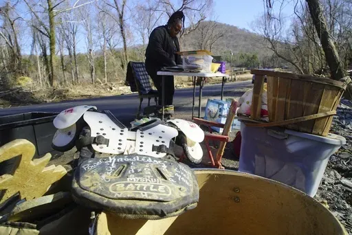 Football shoulder pads belonging to Angie McGee's son, Link, rest on a pile of found objects as she looks through mud-encrusted photos on Friday, Feb. 7, 2025, in Swannanoa, N.C. (AP Photo/Allen G. Breed)