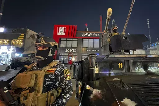 Iraqi security forces stand guard in front of Kentucky Fried Chicken restaurant in Baghdad, Wednesday, June 5, 2024. The recent protests — apparently organised by supporters of Iran-backed, anti-American militias in Iraq — reflect surging anger against the United States, Israel’s top ally, over the war in Gaza. (AP Photo/Ali Jabar)