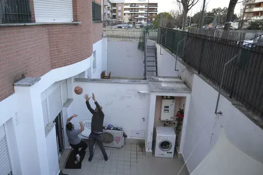 Hasan Zaheda plays basketball with his son Riad in the courtyard of their house in Rome, Sunday, March 2, 2025. (AP Photo/Alessandra Tarantino)