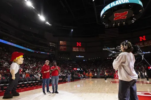 Travis Weber of Lincoln, left, holds the keys to his 2025 Porsche Macan as Dewayne Taylor speaks to the crowd before Illinois plays against Nebraska in an NCAA college basketball game Thursday, Jan. 30, 2025, in Lincoln, Neb. Weber made a putt the length of the basketball court during a Jan. 22 men's basketball game between Southern California and Nebraska to win a 2025 Porsche Macan valued at $75,000. (AP Photo/Rebecca S. Gratz)