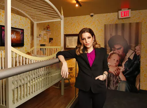 Lisa Marie Presley stands next to her childhood crib displayed with other mementos in the new exhibit "Elvis Through His Daughter's Eyes," at Graceland in Memphis, Tenn., Jan. 31, 2012. She was born on Feb. 1, 1968. Lisa Marie Presley, singer and only child of Elvis, died Thursday, Jan. 12, 2023, after a hospitalization, according to her mother, Priscilla Presley. She was 54. (AP Photo/Lance Murphey, File)