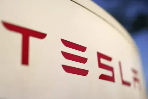 The logo for the Tesla Supercharger station is seen in Buford, Ga, April 22, 2021. Faced with falling global sales and a tumbling stock price, Tesla has slashed prices again on some of its electric vehicles and its “Full Self Driving” system. Tesla releases first-quarter earnings Tuesday, April 23, 2024. (AP Photo/Chris Carlson, File)