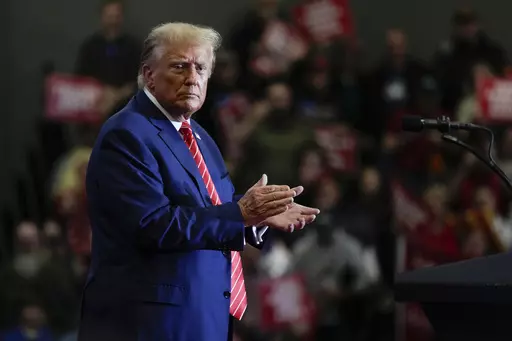 Republican presidential candidate former President Donald Trump stands on stage after speaking during a commit to caucus rally, Saturday, Jan. 6, 2024, in Clinton, Iowa. (AP Photo/Charlie Neibergall)