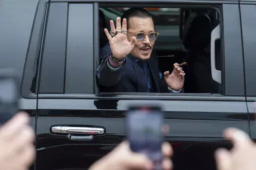 Actor Johnny Depp waves to supporters as he departs the Fairfax County Courthouse Friday, May 27, 2022 in Fairfax, Va.  A jury heard closing arguments in Johnny Depp's high-profile libel lawsuit against ex-wife Amber Heard. Lawyers for Johnny Depp and Amber Heard made their closing arguments to a Virginia jury in Depp's civil suit against his ex-wife.(AP Photo/Craig Hudson)