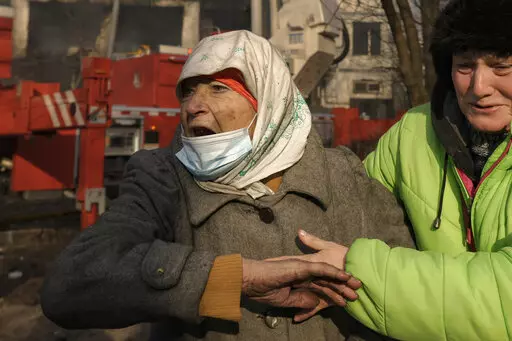 Women cry outside a destroyed apartment building after a bombing in a residential area in Kyiv, Ukraine, Tuesday, March 15, 2022. Russia's offensive in Ukraine has edged closer to central Kyiv with a series of strikes hitting a residential neighborhood as the leaders of three European Union member countries planned a visit to Ukraine's embattled capital. (AP Photo/Vadim Ghirda)