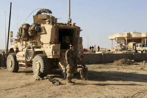 U.S. Army soldiers stand outside their armored vehicle on a joint base with the Iraqi army, south of Mosul, Iraq, Feb. 23, 2017. (AP Photo/ Khalid Mohammed, File)