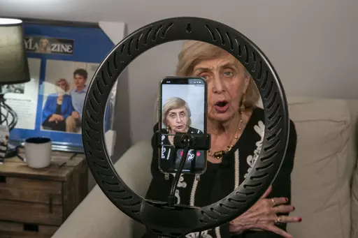 Holocaust survivor Tova Friedman, 85, prepares to record a TikTok video with her grandson, 17-year-old Aron Goodman, in Morristown, New Jersey, on Monday, March 13, 2023. Goodman records TikTok videos of his grandmother describing her experiences as a six-year-old at Auschwitz concentration camp that have millions of views on the social media platform. (AP Photo/Ted Shaffrey)