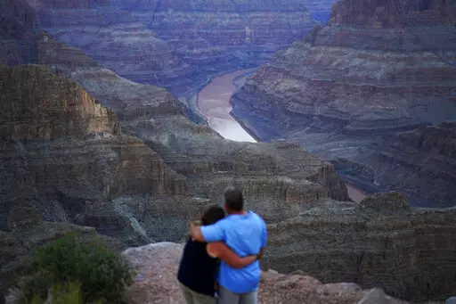 Alyssa Chubbuck, left, and Dan Bennett embrace while watching the sunset at Guano Point overlooking the Colorado River on the Hualapai reservation Monday, Aug. 15, 2022, in northwestern Arizona. In November 1922, seven land-owning white men brokered a deal to allocate water from the Colorado River, which winds through the West and ends in Mexico. During the past two decades, pressure has intensified on the river as the driest 22-year stretch in the past 1,200 years has gripped the southwestern U