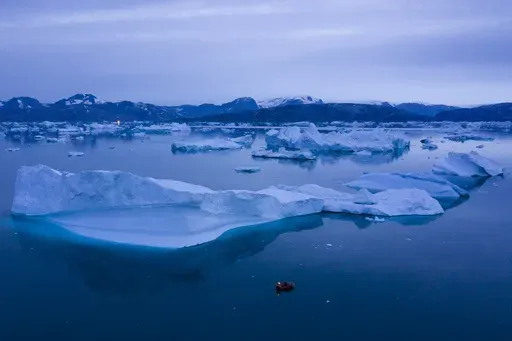 A boat navigates large icebergs near the town of Kulusuk, in eastern Greenland, on Aug. 15, 2019. (AP Photo/Felipe Dana, File)