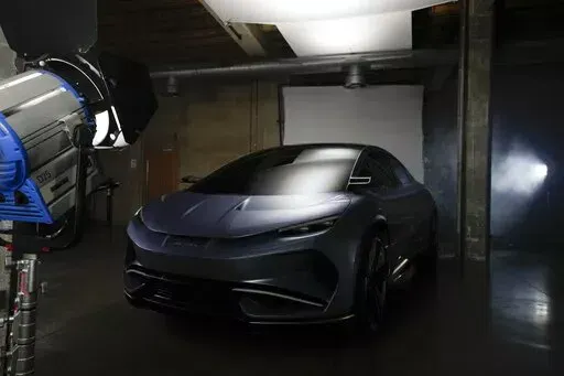 The Aehra new electric vehicle is lit on a set for a photo shoot in Milan, Italy, Thursday, Oct. 20, 2022. Tesla paved the way nearly two decades ago. Now the road to full-electric vehicle transition is littered with startups, inspired by a new era in mobility, and drawn by the lower cost of building EVs compared with their fossil-fuel guzzling forbears. (AP Photo/Luca Bruno)