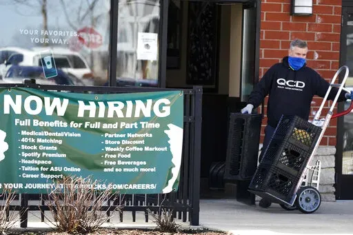 A hiring sign is displayed outside of a Starbucks in Schaumburg, Ill., Friday, April 1, 2022.  The number of Americans applying for jobless aid ticked up slightly last week but the total number of Americans collecting benefits remained at its lowest level in more than five decades. Applications for unemployment benefits rose by 1,000 to 203,000 for the week ending May 7, the Labor Department reported Thursday, May 12.  (AP Photo/Nam Y. Huh)