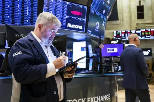 In this photo provided by the New York Stock Exchange, a pair of traders work on the floor, Thursday, April 7, 2022. Stocks shifted between small gains and losses in morning trading on Wall Street Thursday as investors continue weighing the latest updates from the Federal Reserve amid concerns about rising inflation. (David L. Nemec/New York Stock Exchange via AP)