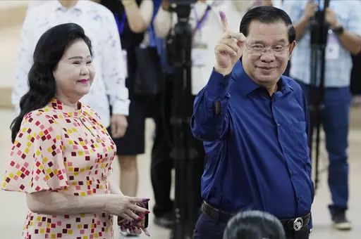 Cambodian Prime Minister Hun Sen, right, of the Cambodian People's Party (CPP) shows off his inked finger, standing next to his wife Bun Rany, left, after voting a ballot at a polling station in Takhmua in Kandal province, southeast Phnom Penh, Cambodia, Sunday, July 23, 2023. Cambodians go to the polls Sunday with incumbent Prime Minister Hun Sen and his party all but assured a landslide victory thanks to the effective suppression and intimidation of any real opposition that critics say has mad