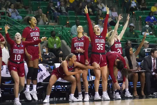 The South Dakota bench celebrates during the second half of a college basketball game against Mississippi in the first round of the NCAA tournament in Waco, Texas, Friday, March 18, 2022. South Dakota won 75-61. (AP Photo/LM Otero)