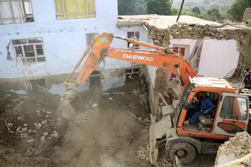 An excavator removes mud from a damaged house after heavy flooding in the Maidan Wardak province in the central of Afghanistan, Sunday, July 23, 2023. Heavy flooding from seasonal rains in Afghanistan killed multiple people and left dozens missing over the past three days. (AP Photo)