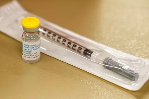 A vial containing the monkeypox vaccine and a syringe is set on the table at a vaccination clinic run by the Mecklenburg County Public Health Department in Charlotte, N.C., Saturday, Aug. 20, 2022. At-risk people who received just one dose of the monkeypox vaccine appeared to be significantly less likely to get sick from the virus, public health officials announced Wednesday, even as they urged a second dose for full protection. (AP Photo/Nell Redmond, File)