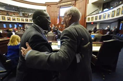 Florida Sen. Dennis Baxley, right, the sponsor of a bill, dubbed by opponents as the "Don't Say Gay" bill, hugs an opponent of the bill, Sen. Shevrin Jones, after the bill passed during a legislative session at the Florida State Capitol, Tuesday, March 8, 2022, in Tallahassee, Fla. (AP Photo/Wilfredo Lee)