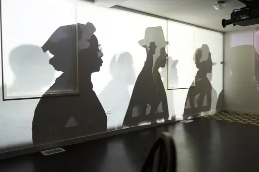 A video projection by Manual Cinema uses animation, shadow puppets and oral installation to help museum visitors "understand why more than 50 years after the Fair Housing Act of 1968, we are still living in a segregated world with a growing racial wealth gap," according to the National Public Housing Museum, Wednesday, March 19, 2025, in Chicago. (AP Photo/Erin Hooley)