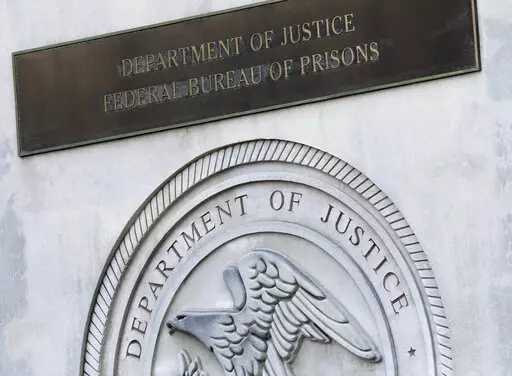 A sign for the Department of Justice Federal Bureau of Prisons is displayed at the Metropolitan Detention Center in the Brooklyn borough of New York,  July 6, 2020. The Justice Department has settled a long-running lawsuit filed by a group of men rounded up in the weeks after the September 2001 attack who say they were abused in a federal lockup in New York City. (AP Photo/Mark Lennihan, File)